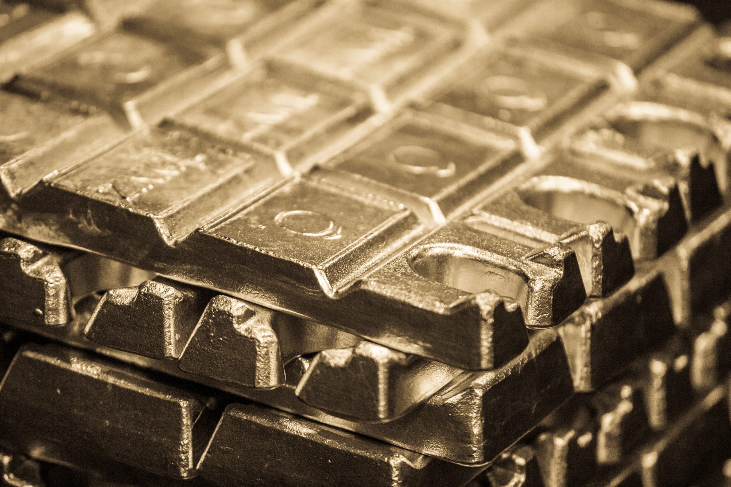 Close-up of stacked zinc (zamak) and aluminum die-casting ingots, showcasing Bruschi's expertise in precision metal components.