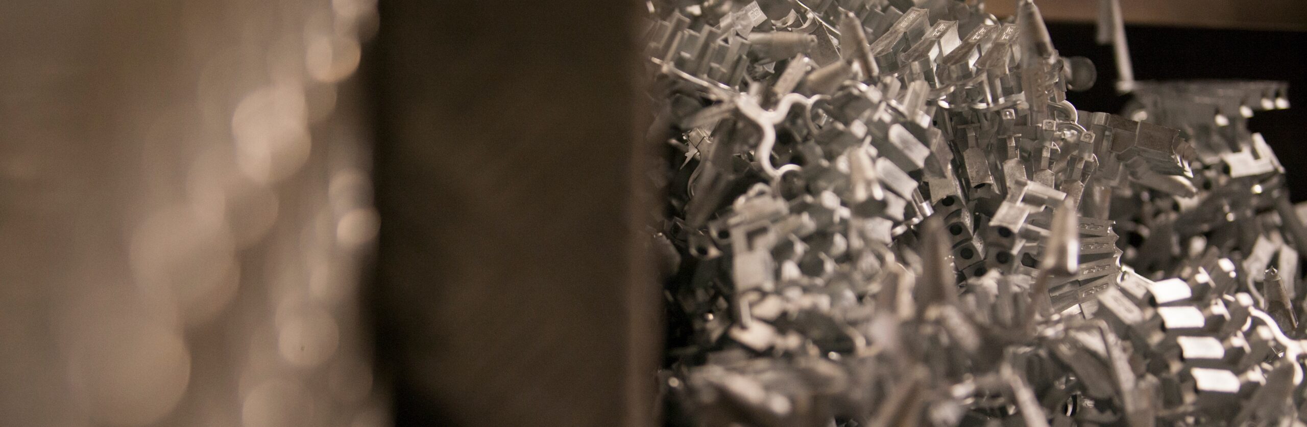 Bruschi: Precision Die Casting of Zamak and Aluminum Components Close-up of a pile of precisely die-cast zinc (zamak) and aluminum components, showcasing Bruschi's expertise in metal casting.