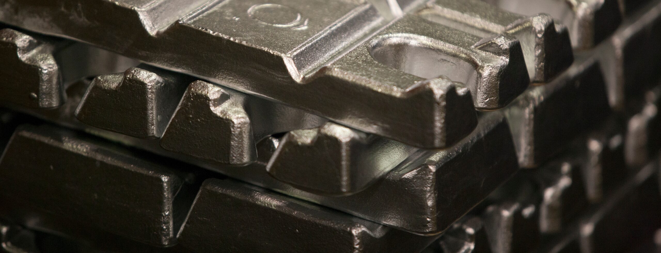 Close-up of stacked zinc (zamak) and aluminum die-casting ingots, showcasing Bruschi's precision and quality in metal component manufacturing.